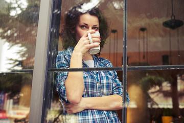 woman drinking the coffee and looking into the distance