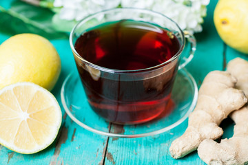 Cup of tea with lemon and honey on wooden background