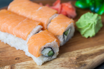 Sushi roll with salmon and shrimp tempura on wooden table