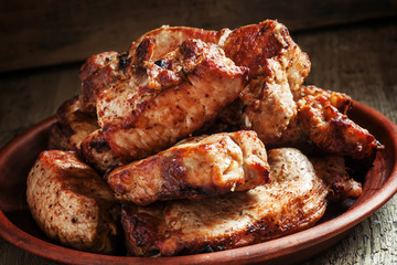 Pieces of shish kebab, grilled, on a clay dish, old wooden backg