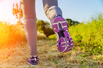 Woman running at sunset in a field