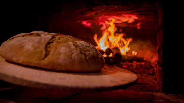Freshly baked bread going out of the bread oven