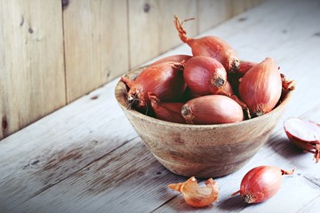 Shallot on a rustic wooden table.Selective focus - obrazy, fototapety, plakaty