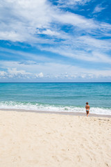 Fototapeta na wymiar Little girl walking on the beach, beach vacation
