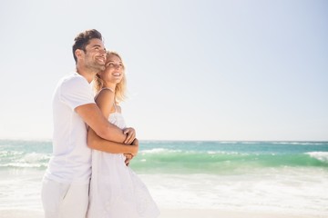 Smiling young couple hugging on the beach