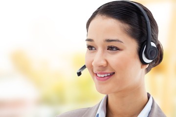 Composite image of happy operator posing with a headset