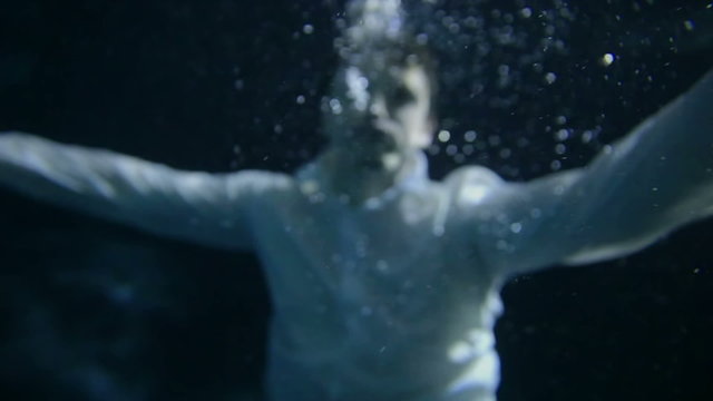 A young man stops breating under water