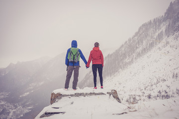 A man and a woman at the top of a snowy mountain 