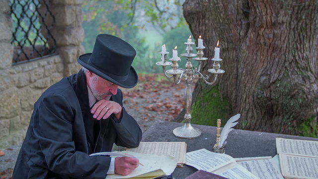 Man from romantic times writing outdoors