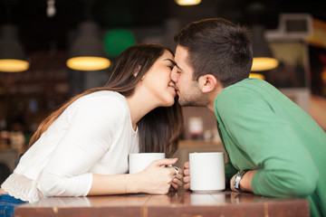 Kissing across the table in a restaurant