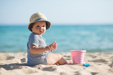 Beautiful boy playing on beach with toys 