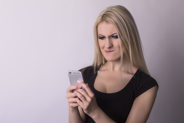Fototapeta premium Nervous woman looking on mobile phone