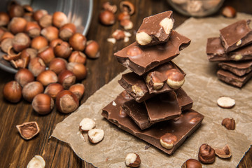 Плитки шоколада на бумаге с лесными орехами