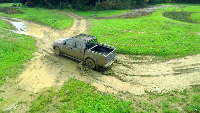 The water is splashing when truck is driving through mud puddles