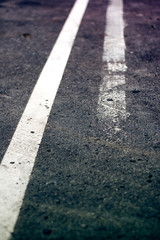 Weathered double white line on asphalt road