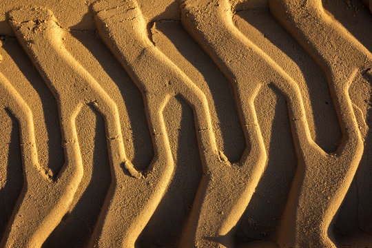 embossed trail excavator tracks on the wet sand. texture of sand