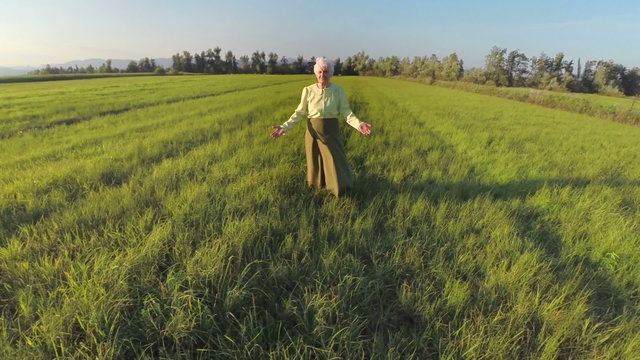 Old woman feel the wind at sunset of her life