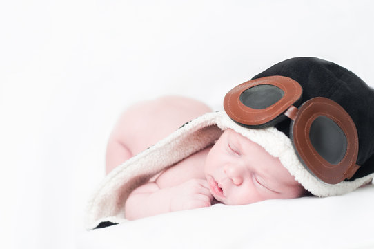 naked baby boy sleeping in a pilot hat
