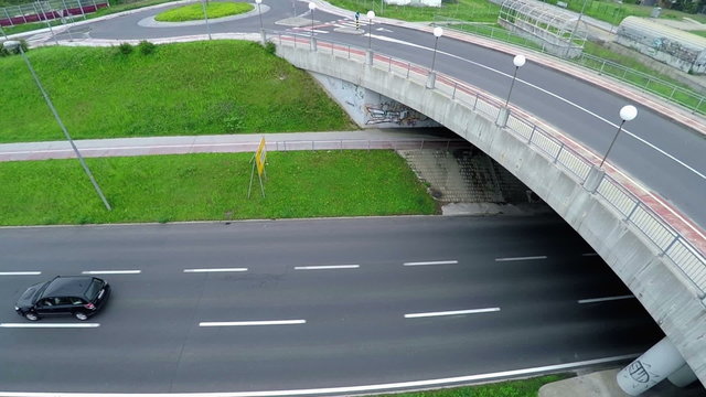Cars are driving on a highway under a bridge