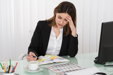 Tired Businesswoman Writing Schedule In Diary