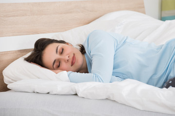 Fototapeta na wymiar Woman Sleeping On Bed