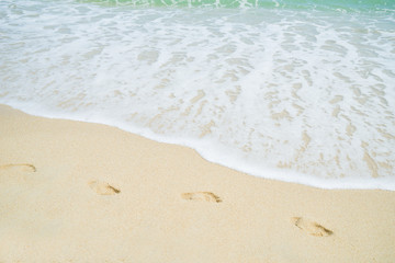 Fototapeta na wymiar Footsteps on the beach by the sea