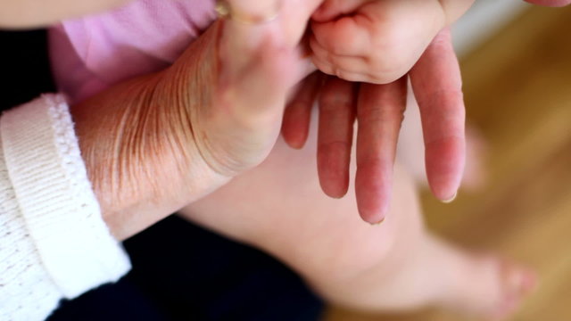 Hands of baby and grandma