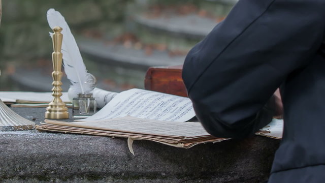 Man starting to write a poem at a stone table 