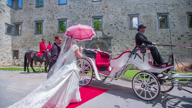 A bride and groom getting into a carriage