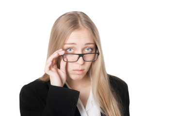Beautiful puzzled business woman lifting her glasses in surprise