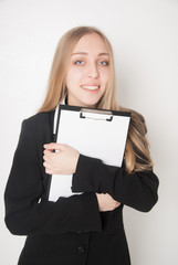 Naklejka premium Smiling young woman holding a blank clipboard (isolated on white