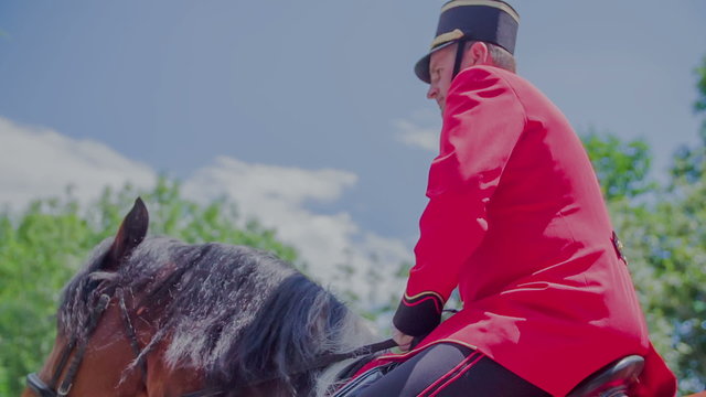 A man in a uniform riding a horse