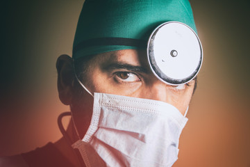Doctor Head Mirror. Physician wearing scrubs, surgical mask and head mirror, portrait.
