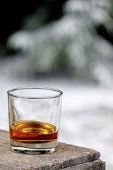 Bourbon Whiskey in a glass with snowy winter background