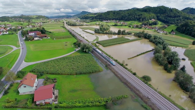 Flying over train stopping beside flooded countryside fields