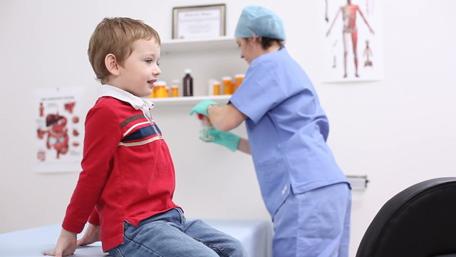Nurse giving young boy lollipop