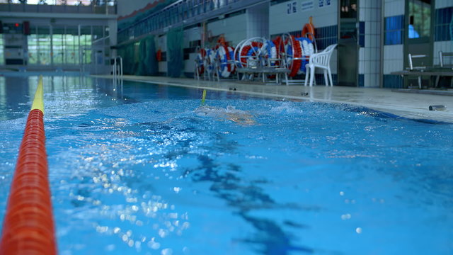 Men is swimming under water in pool