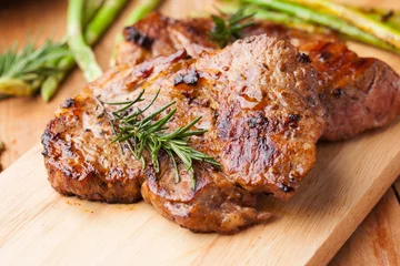 Foto op Plexiglas grilled pork chop with rosemary on wooden board © klaikungwon