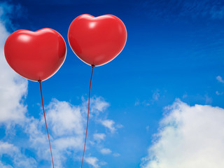 Fototapeta na wymiar shiny red heart shape balloons with blank space on blue sky background