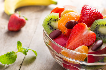Diet-Fresh tasty mix fruit salad in the bowl on the wooden table