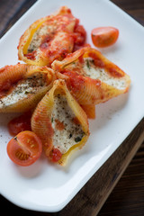 Closeup of conchiglioni baked with cottage cheese stuffing