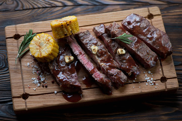 Medium rare grilled rancho steak on a wooden serving board