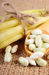 Seeds and stack of yellow beans on jute canvas, healthy food