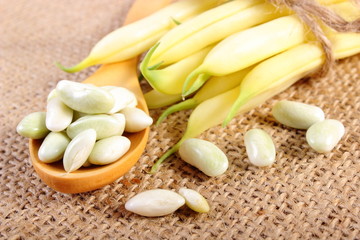 Seeds and stack of yellow beans on jute canvas, healthy food