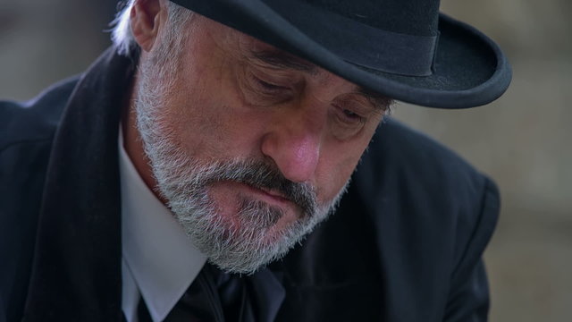 Man from romantic times looks up while writhing a poem