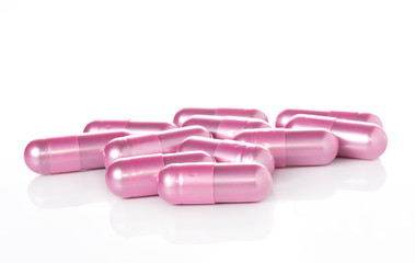 pink pill capsules on white background