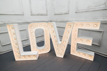 Custom made L O V E letters with light bulb in the corner of vintage room