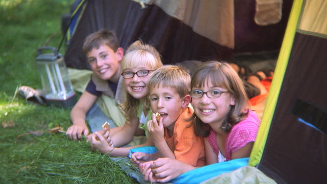 Group of children in tent smiling at camera