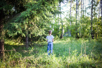 Young guy  standing in a forest on the grass