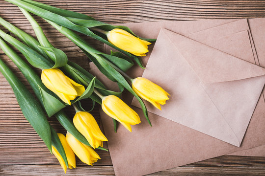 Yellow Tulips And Envelope On Wooden Table